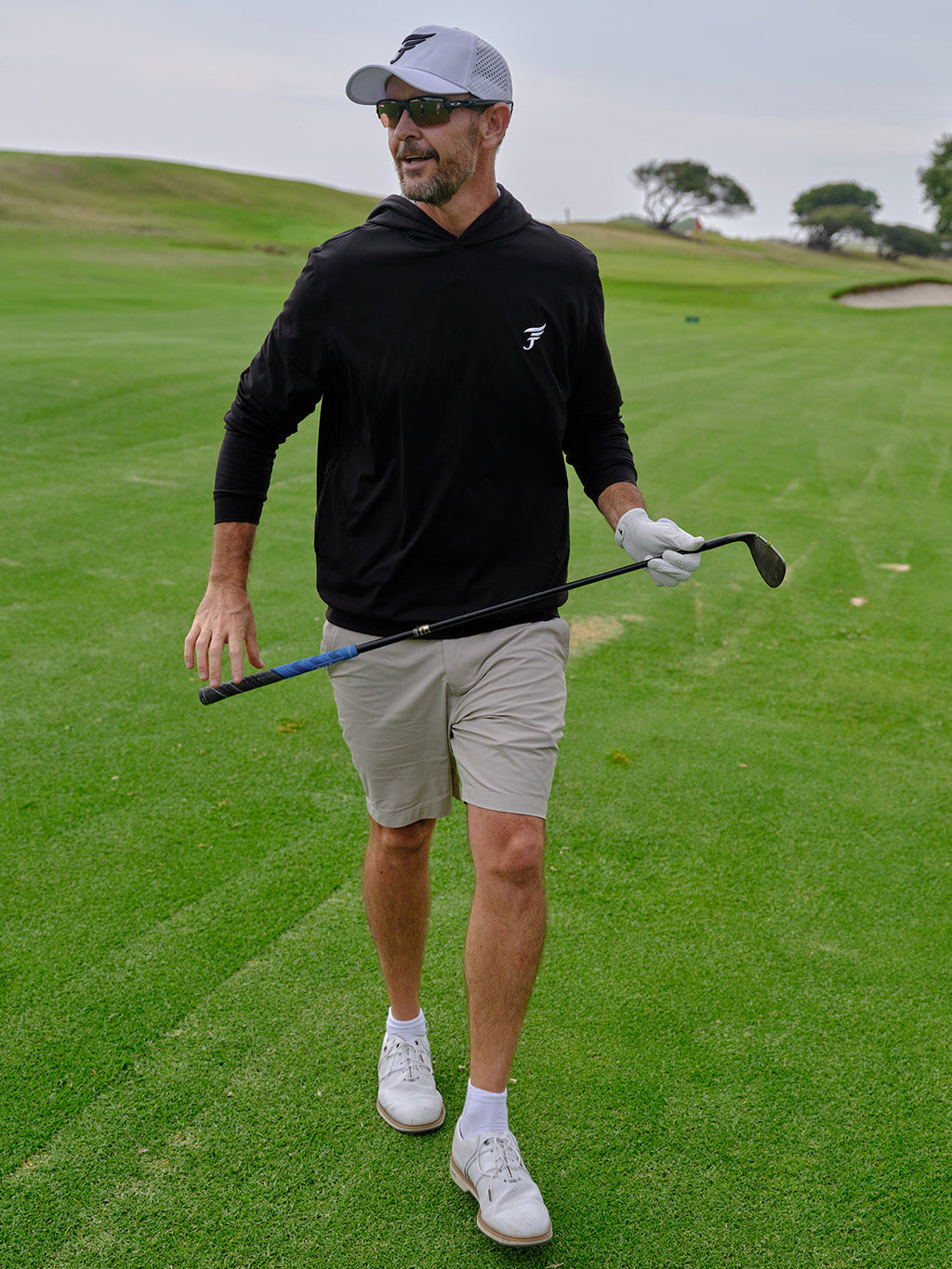Man on a golf course holding a golf club